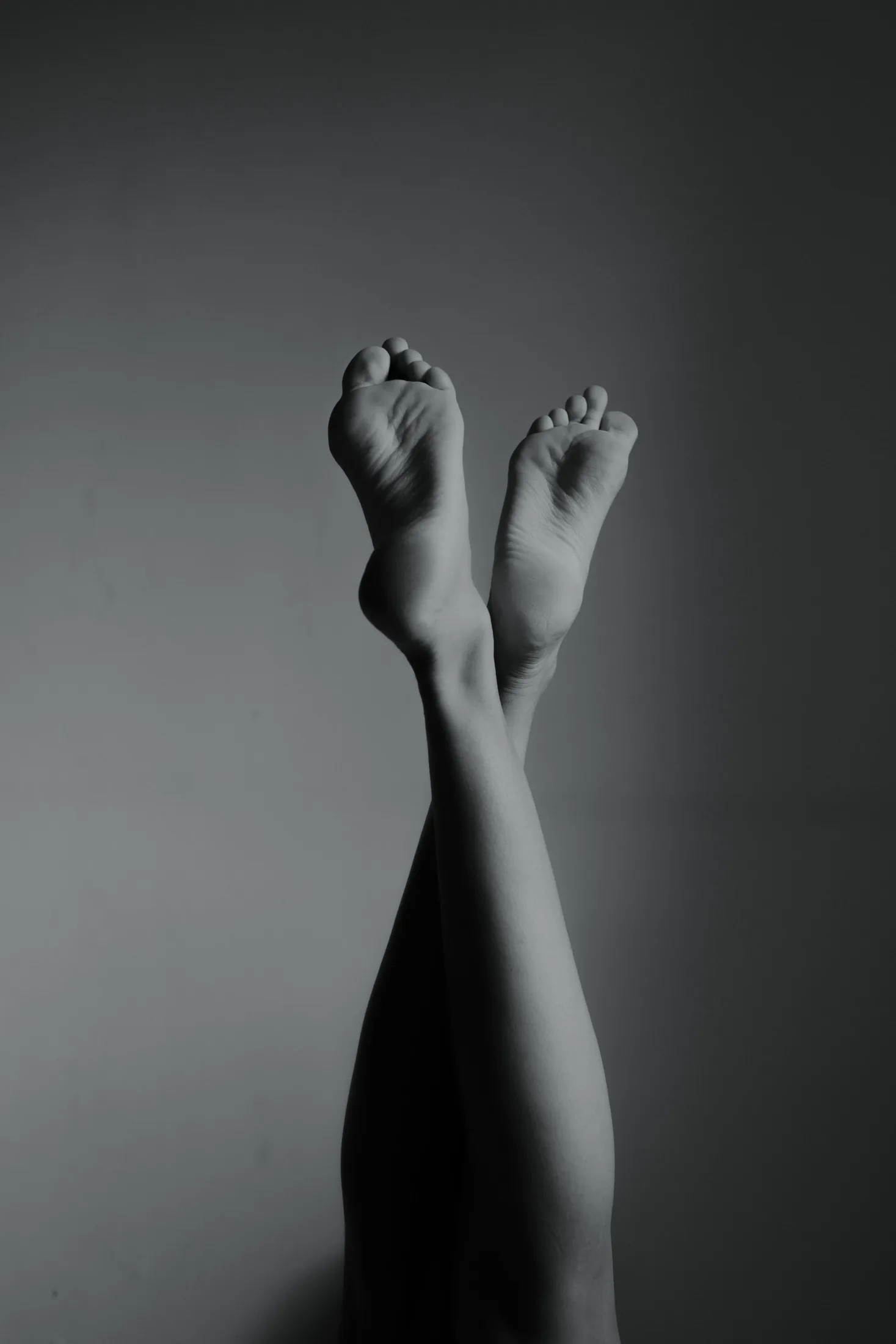 Crossed bare feet in a resting pose, illustrating sensory grounding and body awareness during intimacy.