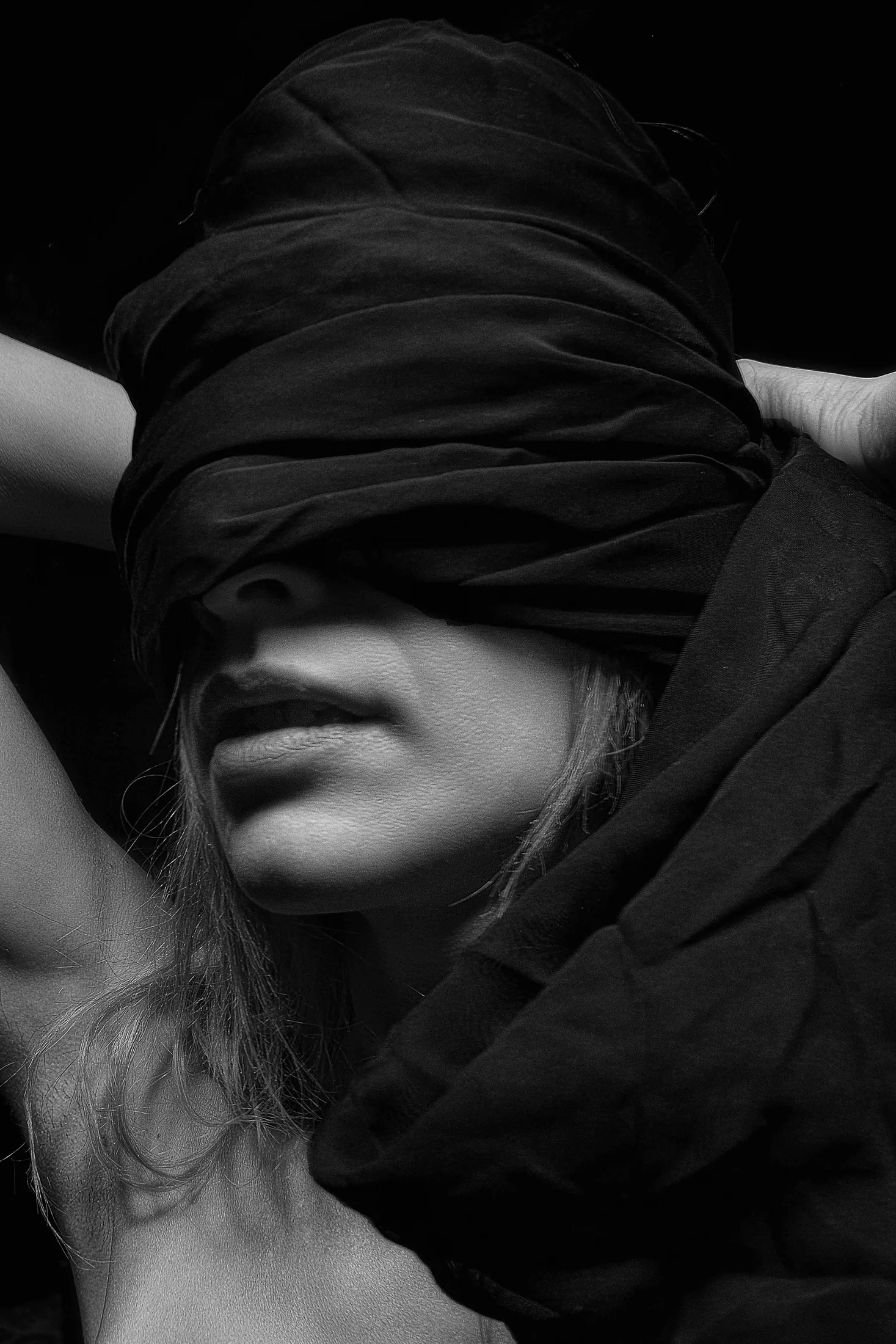 Black-and-white portrait of a person with their eyes covered, evoking attention, distraction, and sexual mindfulness.
